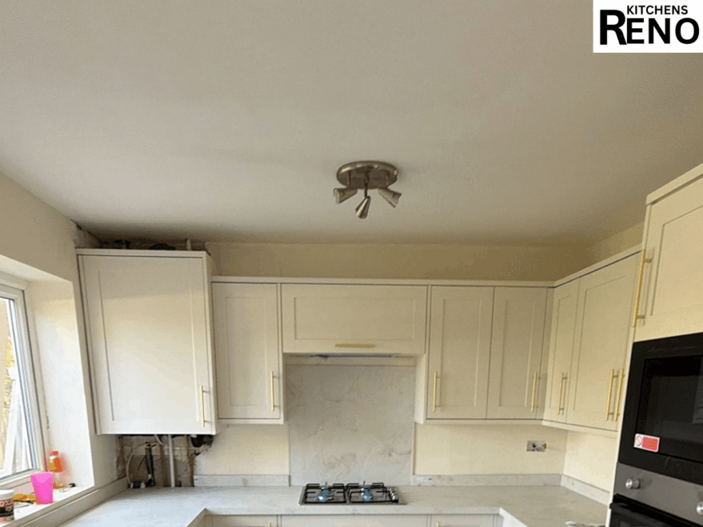Kitchen Renovation Before & After in Liverpool featuring a completed modern shaker-style kitchen with white cabinets, gold handles, marble-effect worktops, integrated appliances, and a gas hob.