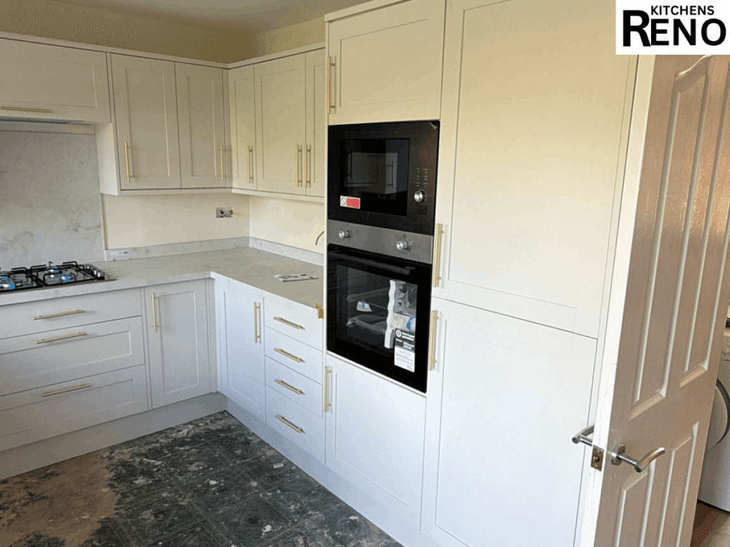 Kitchen Renovation Before & After in Liverpool featuring white shaker kitchen cabinets, integrated double oven, tall pantry unit, marble-effect worktops, and brushed gold handles.